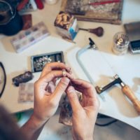 Different goldsmiths tools on the jewelry workplace. Jeweler at work in jewelry. Desktop for craft jewelry making with professional tools. Close up view of tools.